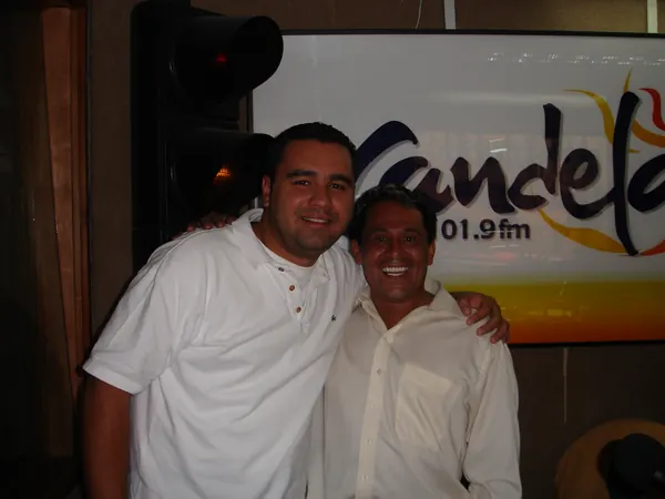 Nelson Vahos frente al logo de Candela Estéreo