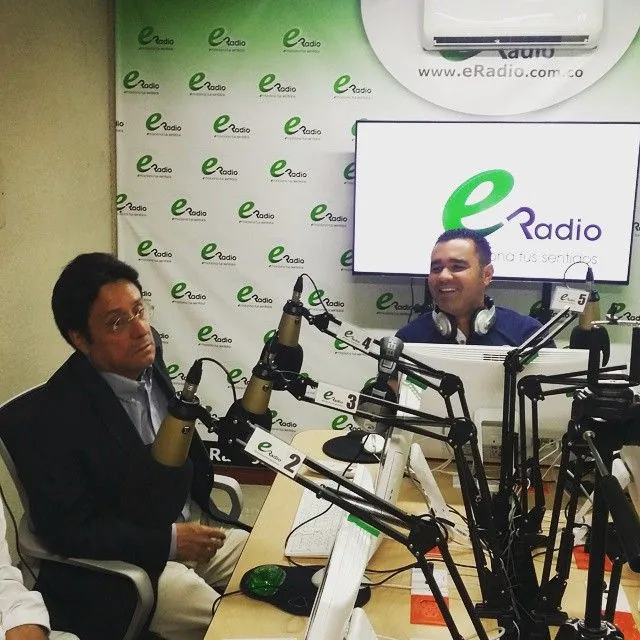 Francisco Santos Calderón conversando con un presentador de eRadio en cabina.